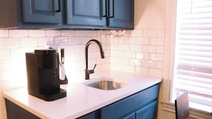 A kitchen with a coffee maker, a sink, and blue cabinets. - Near Riverwalk, Hemisfair, Art & Dining Spots (San Antonio)
