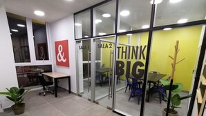 An office space with glass partitions, labeled 'SALA 1' and 'SALA 2', and a 'THINK BIG' motivational poster.