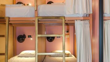 A bunk bed room with a ladder, a mirror, and a fan.