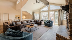 A spacious living room with a sectional sofa, a coffee table, and a stone fireplace. - Lower Deer Valley with Amazing Views, Private Hot Tub, Walk to Old Town (Park City)
