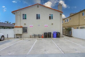 A building with a parking lot, trash bins, and a 'TOW AWAY' sign.