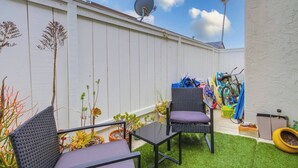 A patio with two chairs, a table, and a satellite dish. - Pet-friendly 1 block to the beach with parking (San Diego)