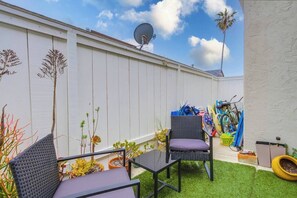 Een terras met twee stoelen, een tafel en een schotelantenne.