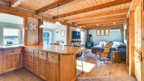 Una cocina amplia con armarios de madera, una isla grande y un comedor con mesa y sillas de madera.