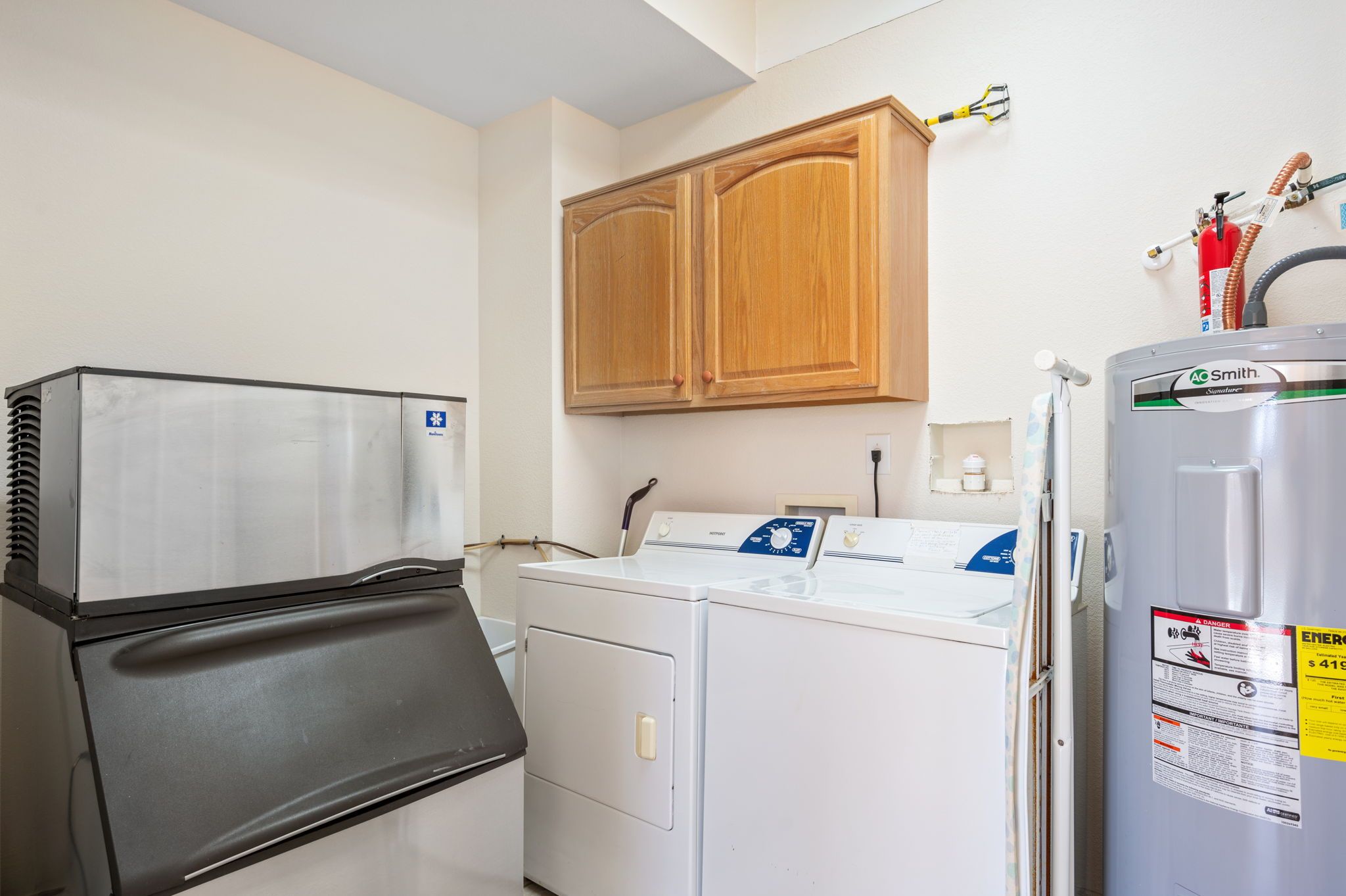 Un espace buanderie compact comprenant un sèche-linge, un lave-linge et un réfrigérateur.