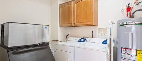 Un espace buanderie compact comprenant un sèche-linge, un lave-linge et un réfrigérateur.