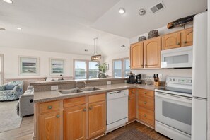 A modern kitchen with wooden cabinets, a built-in dishwasher, a stove, and a microwave.