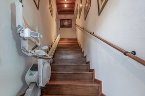 A wooden staircase with a handrail, a wall-mounted lift, and framed artwork on the walls. - Stunning private villa for 12 people with private pool, WIFI, TV and panoramic view (Ostra)