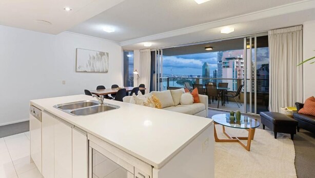 A modern apartment with a kitchen, dining area, and living room. -  Skyline hosted by AAB (Brisbane)
