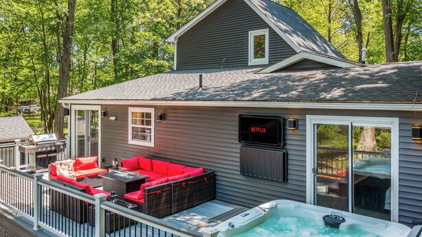 Ein Haus mit Terrasse, Whirlpool und Netflix-Logo.