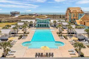 A resort with a central pool, lounge chairs, and a view of the beach. - Resort Pools, Golf Cart Boardwalk to the Beach (Port Aransas)
