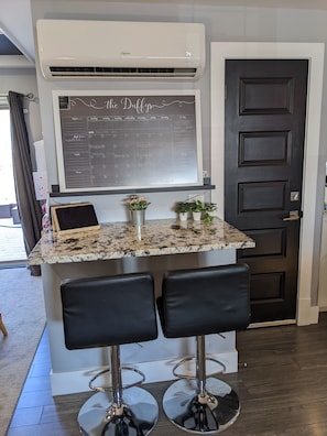 Enjoy cooking in this kitchen with a large countertop, bar stools, and a convenient chalkboard calendar.