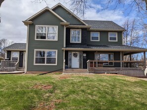 Enjoy a welcoming entrance and expansive outdoor space on this two-story house's front porch and backyard.