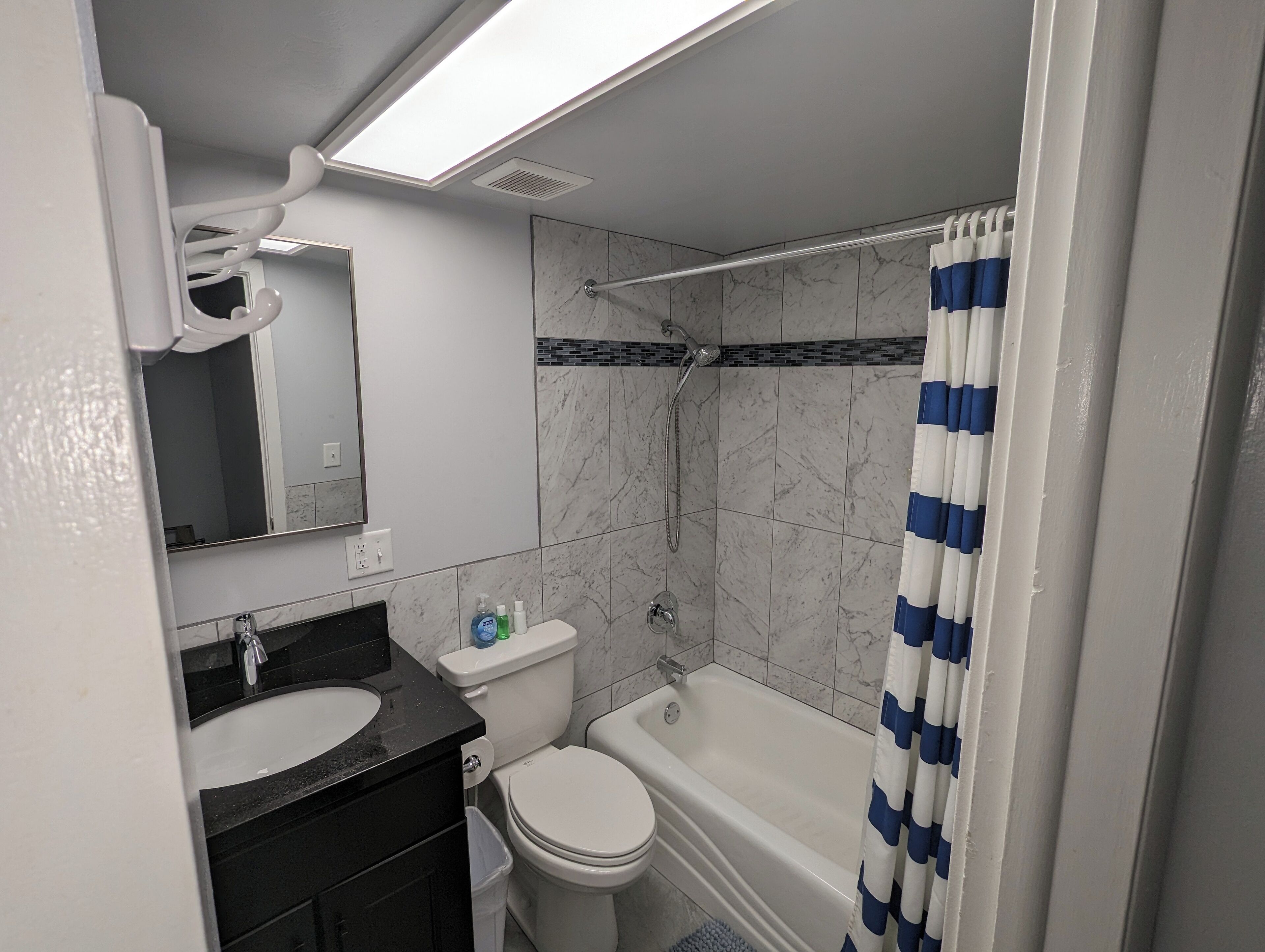 A bathroom with a shower, toilet, and sink.