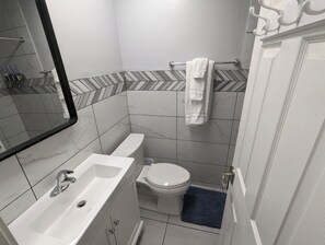 A bathroom with a white sink, a toilet, and a towel rack. - Majestic Rockies Motel (Sandy)