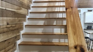 Una scala in legno con gradini bianchi e una ringhiera in legno.