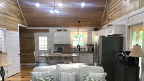 Un accogliente interno in stile chalet con zona pranzo, cucina e angolo salotto.