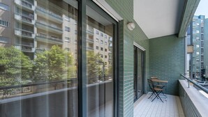 A balcony with a view of a multi-story building, a table and chairs, and a tiled floor. - GuestReady - A breath of fresh air in Nogueiró (Nogueiró)
