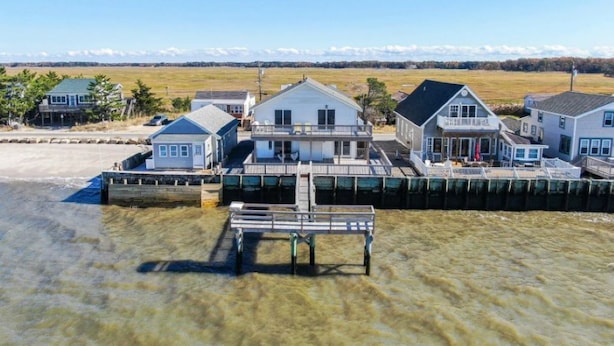 A waterfront property with multiple houses connected by a dock. - Reed's Beach - Stunning waterfront Sunsets - Bay Front Home Steps to beach (Middle Township)