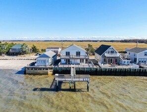 A waterfront property with multiple houses connected by a dock. - Reed's Beach - Stunning waterfront Sunsets - Bay Front Home Steps to beach (Middle Township)