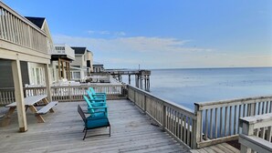 A wooden deck with blue chairs and a view of the ocean. - Reed's Beach - Stunning waterfront Sunsets - Bay Front Home Steps to beach (Middle Township)