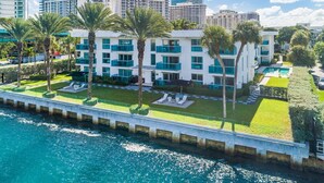A modern hotel with a pool, palm trees, and a view of the ocean. - Accessible Studio with King Size Bed Kitchenette, Steps Away from Bal Harbour Beach (Bal Harbour)