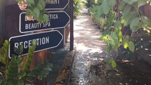 A pathway leading to a building with signs for a pool, restaurant, beauty spa, and reception. - La bastide de Caro (Siem Reap)