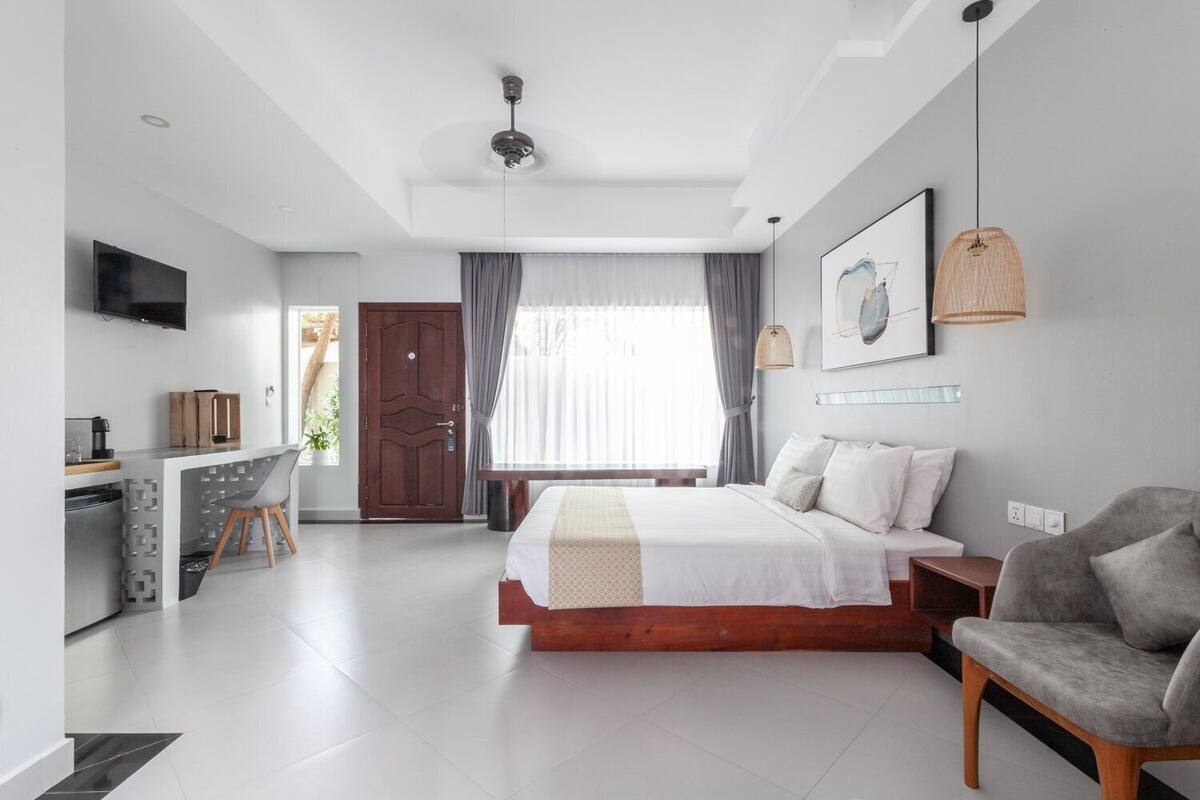 Una habitación de hotel moderna con una cama, un escritorio, una silla y un televisor.