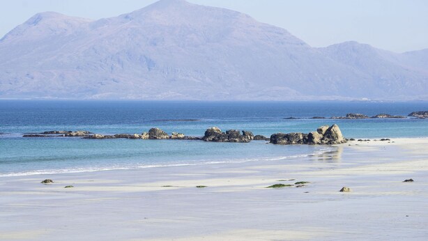 A beach with clear blue water, rocky outcrops, and a mountain in the background. - Cottage 446 - Letterfrack - sleeps 6 guests  in 3 bedrooms (Letterfrack)