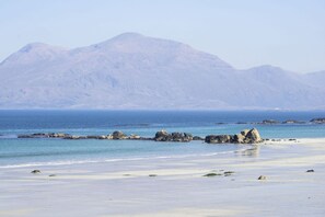 A beach with clear blue water, rocky outcrops, and a mountain in the background. - Cottage 446 - Letterfrack - sleeps 6 guests  in 3 bedrooms (Letterfrack)
