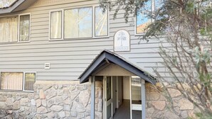 Un bâtiment avec des fondations en pierre, une enseigne indiquant « KIRKWOOD » et une entrée couverte avec un toit.