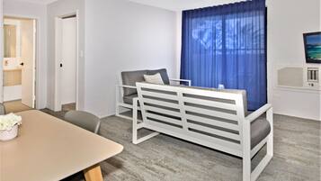 A modern room with a bed, a desk, and a television.