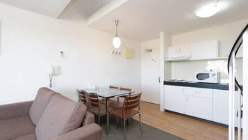 A compact living space with a kitchenette, a dining area, and a sofa.