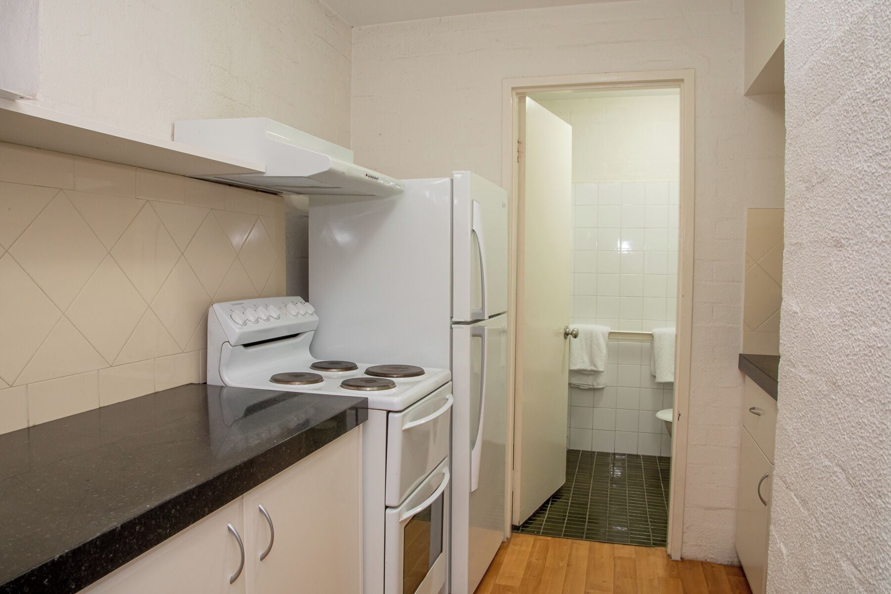Cocina compacta con estufa, horno y refrigerador.