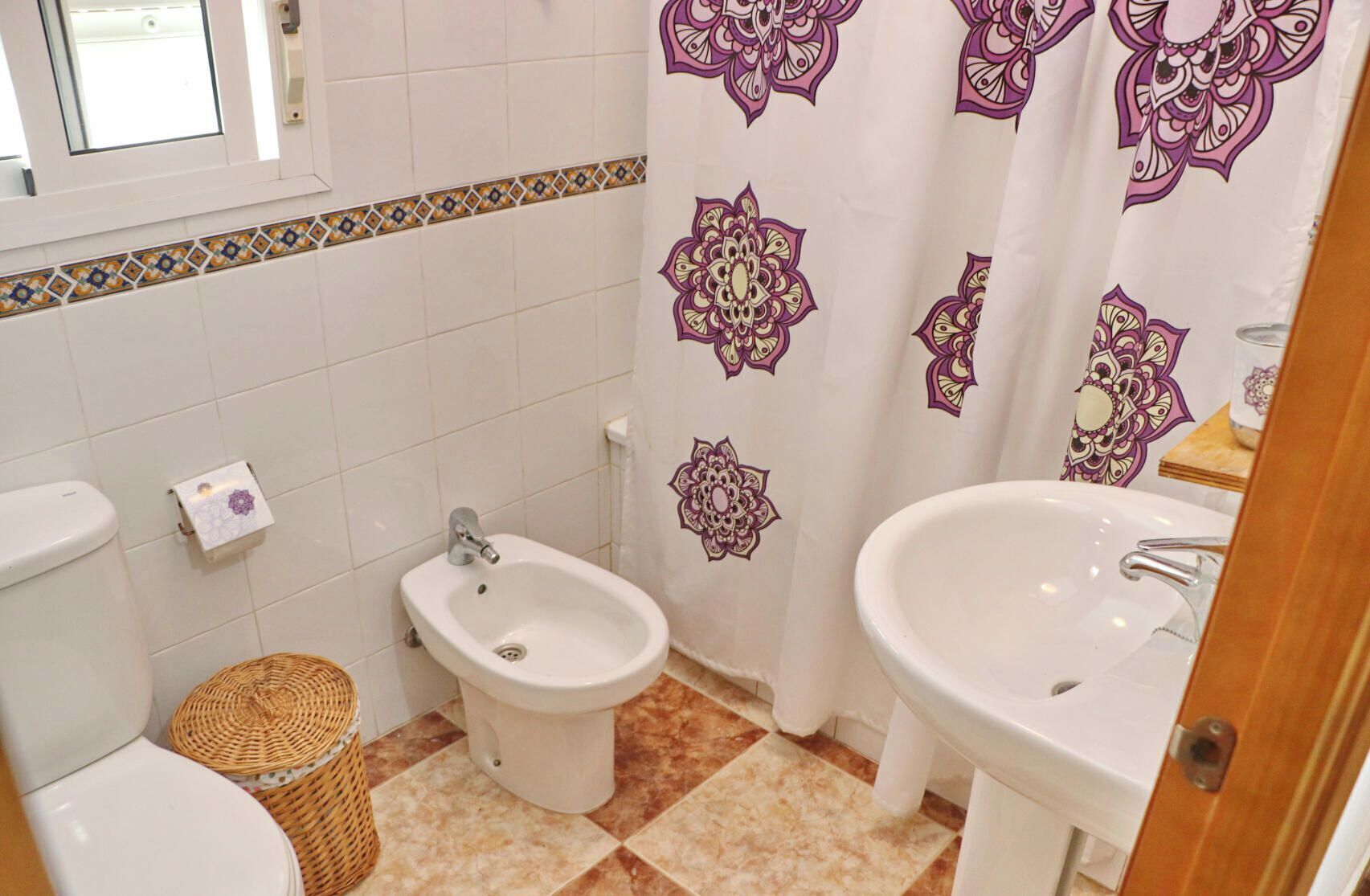 A bathroom with a bidet, toilet, and sink.