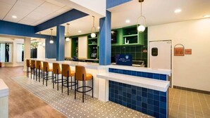 Un espace bar moderne avec un comptoir, des tabourets de bar et une enseigne sur laquelle on peut lire : « La tasse parfaite ».