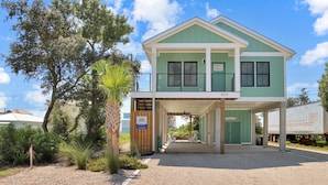 A two-story building with a covered entrance and a gravel driveway. - Emerald Palms 3 (Port St. Joe)