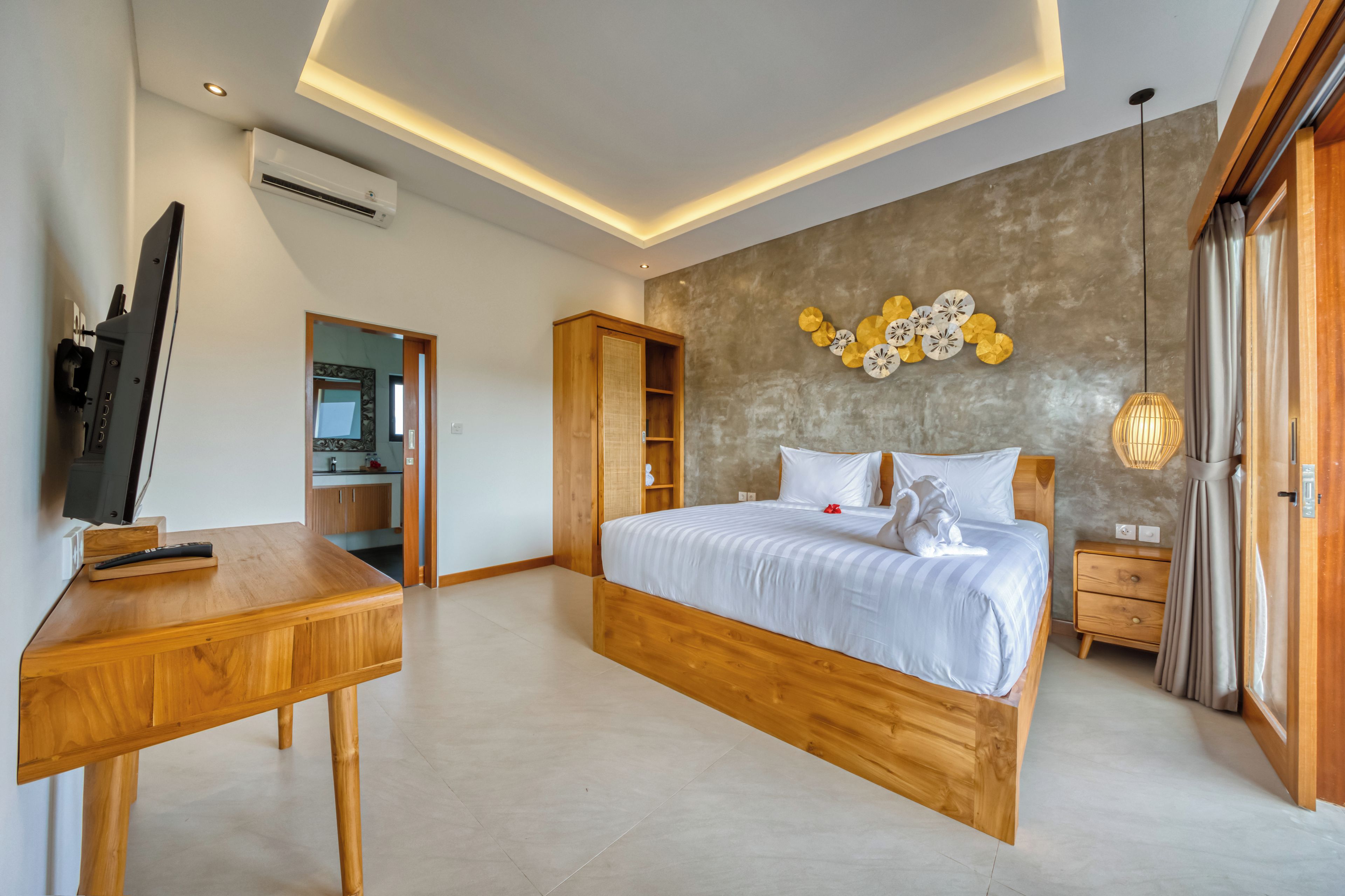 A modern bedroom with a wooden bed, a desk, and a television.