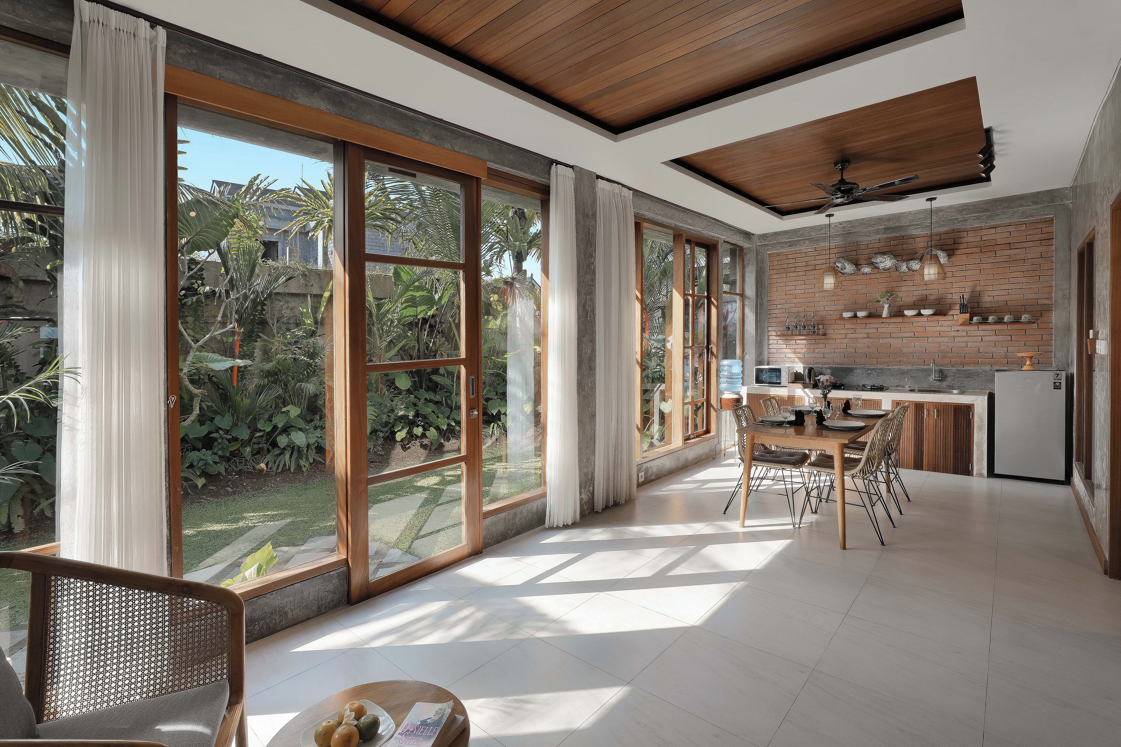 Una cocina amplia con ventanas grandes, un comedor y vistas a un jardín.