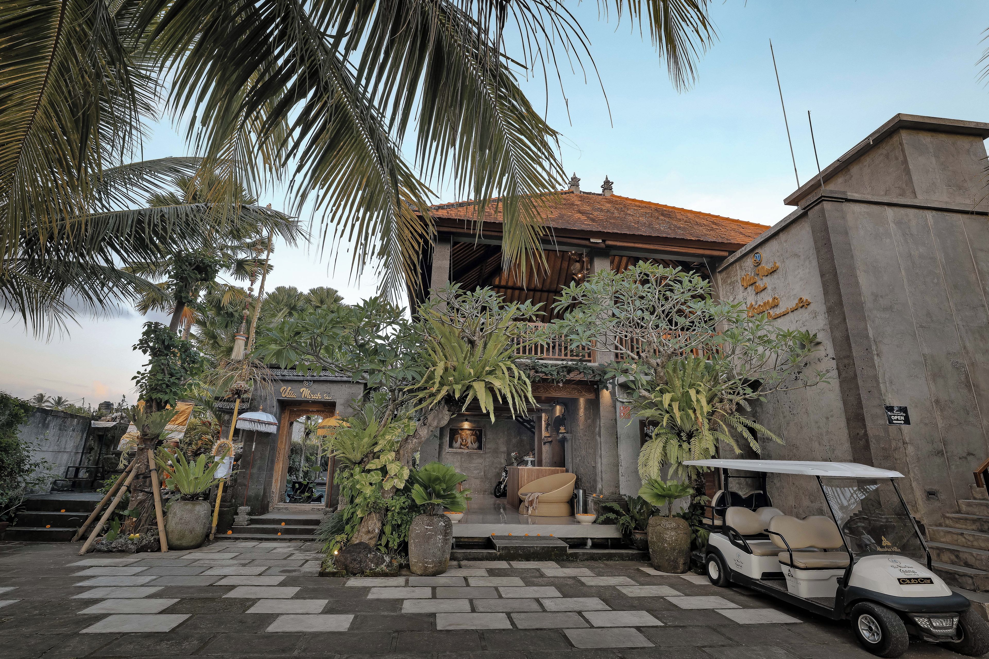 A traditional building with a tiled roof, a signboard, and a golf cart parked in front.