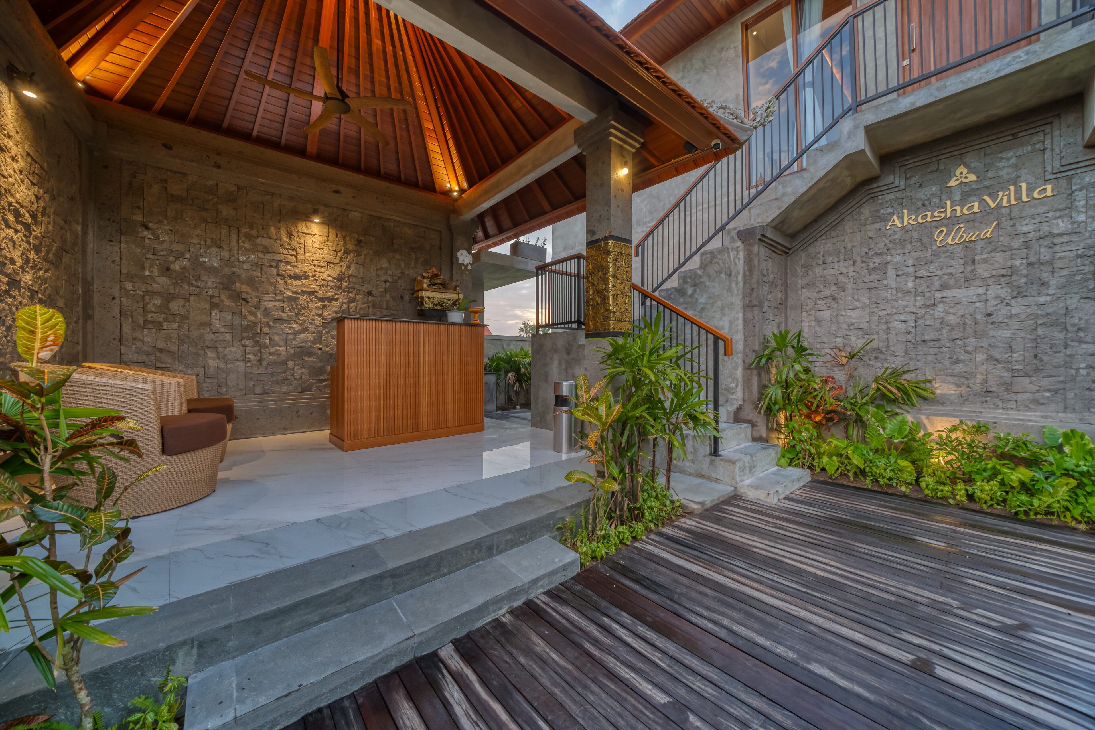A modern villa with a stone exterior, wooden deck, and a balcony with a view.