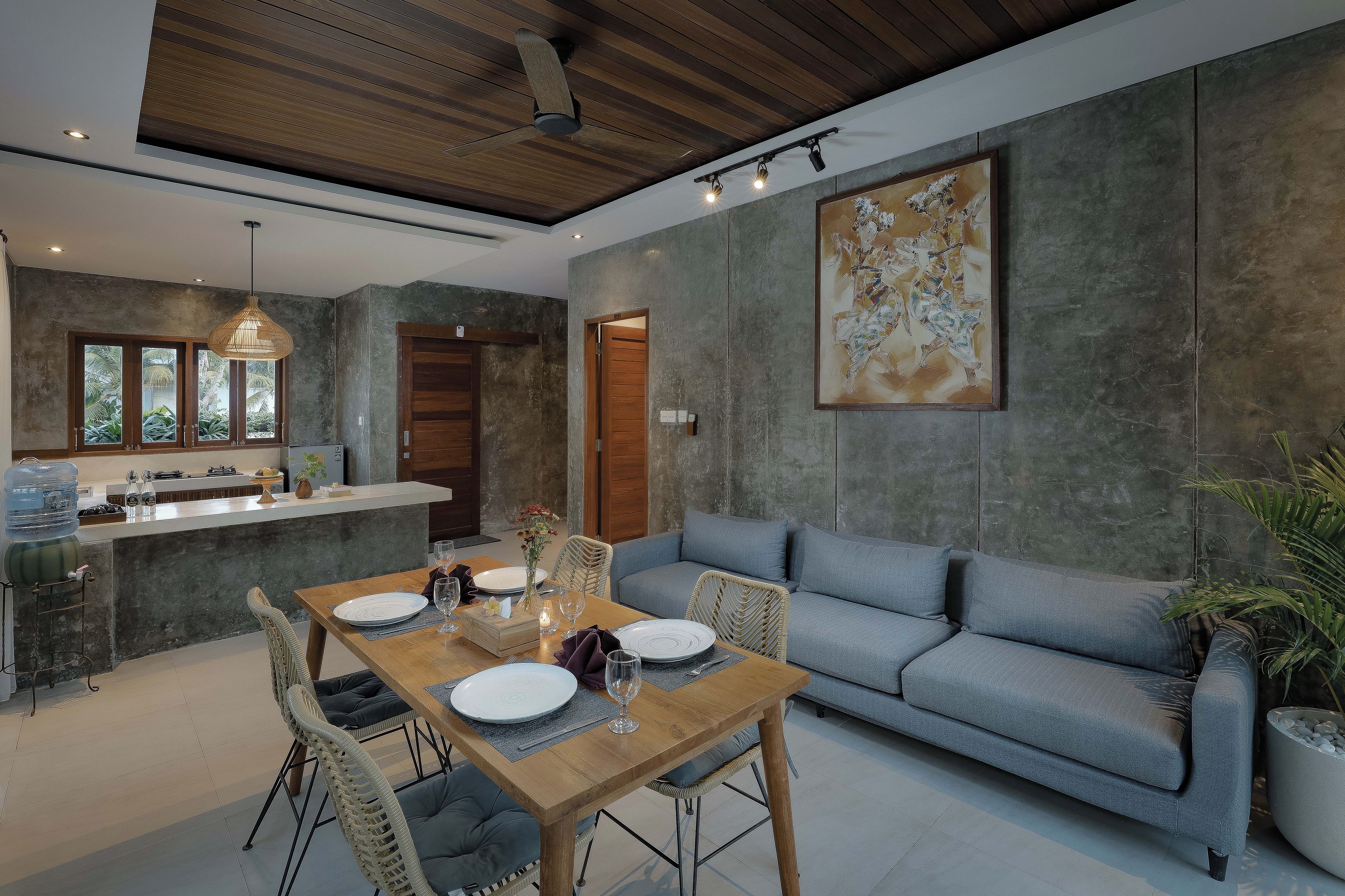 A modern interior with a dining area, sofa, and kitchen.