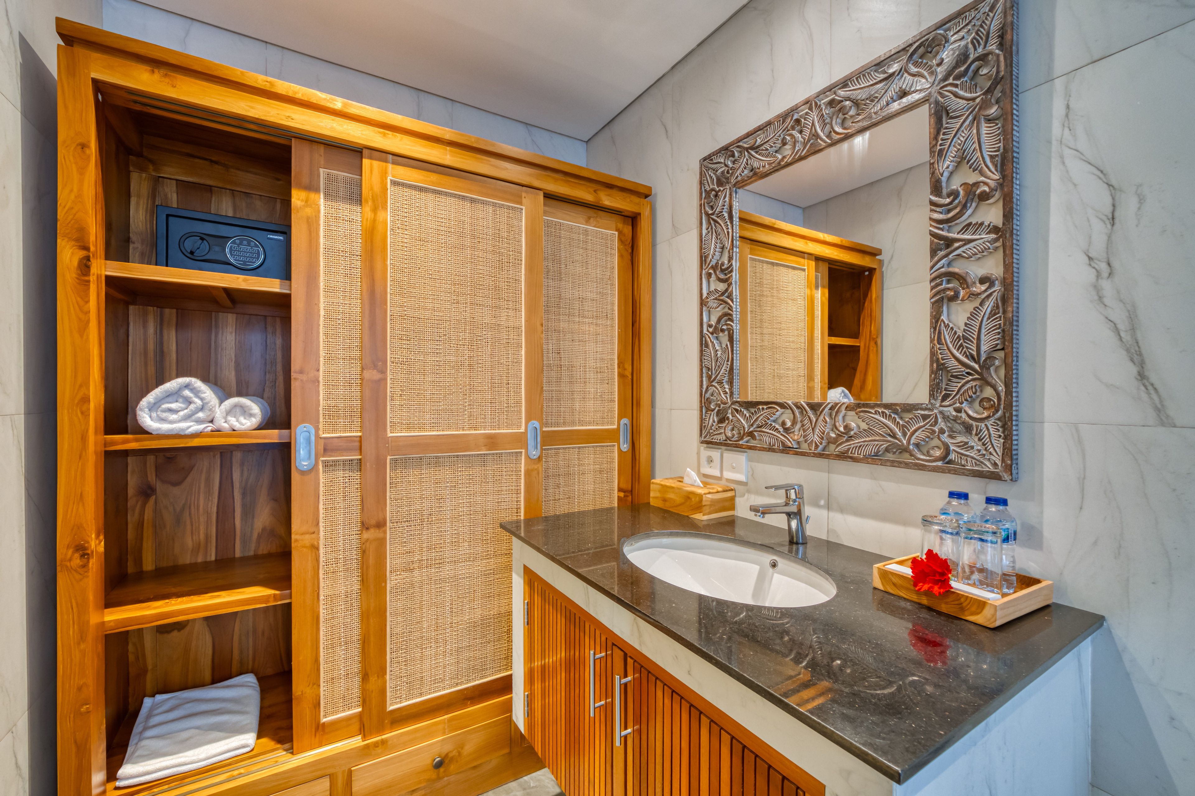 Un baño con tocador de madera, un espejo grande y un calentador empotrado.