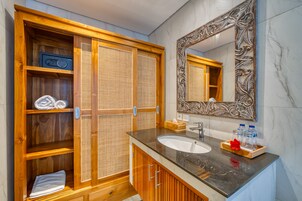 Un baño con tocador de madera, un espejo grande y un calentador empotrado.