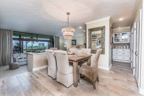 Enjoy meals in this spacious dining area with a large table and comfortable seating for four, offering a view of the surrounding landscape.