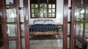 Een kamer met een bed, een raam en een deur.