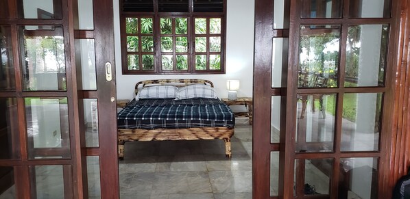 A room with a bed, a window, and a door.