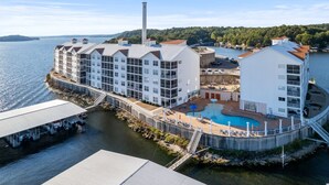 A waterfront hotel with multiple buildings, a swimming pool, and a dock area.