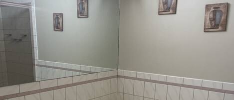Ein Badezimmer mit freistehender Badewanne, gefliesten Wänden und einem Spiegel.