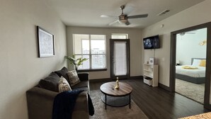Ein modernes Wohnzimmer mit einer Couch, einem Couchtisch und einem Fernseher.